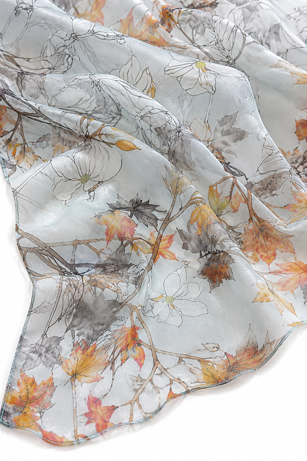 A lightweight sheer scarf with an artistic watercolor floral and autumn leaf print in orange, yellow, brown, and gray on a white background.