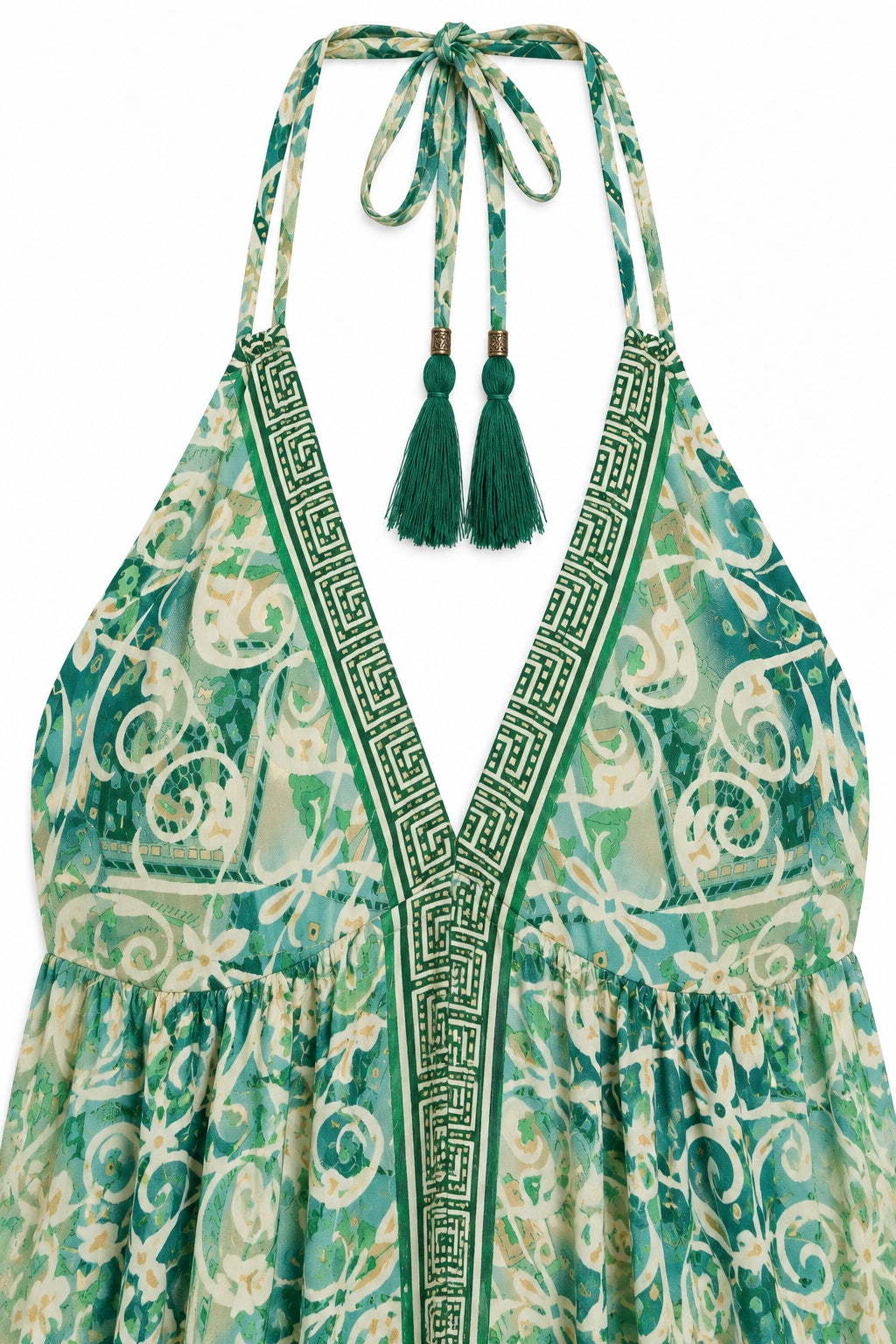 Green and cream patterned halter dress with a deep V-neckline, Greek key trim, and tassel ties at the back, shown on a white background.