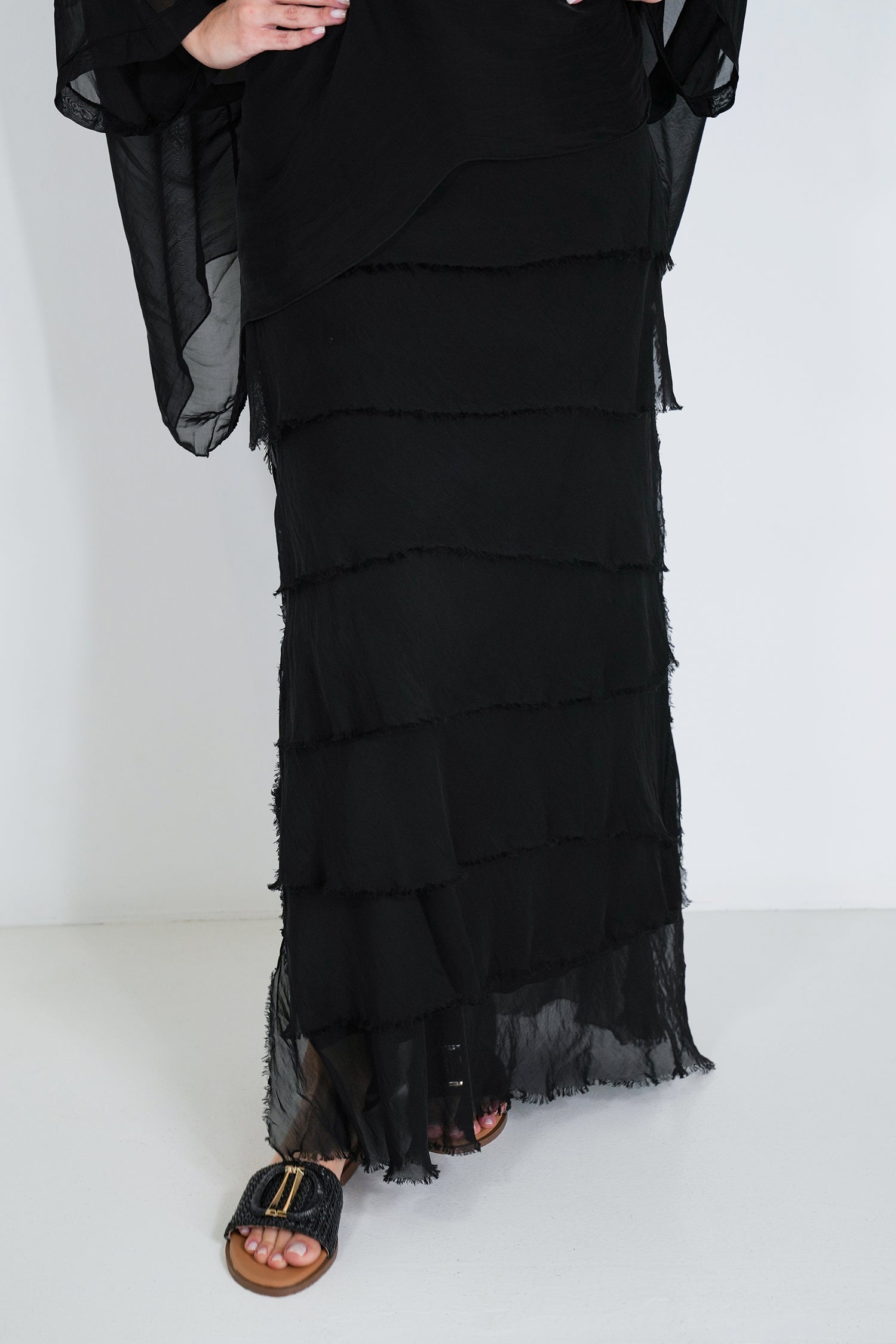 Black layered dress worn by a person on a white background
