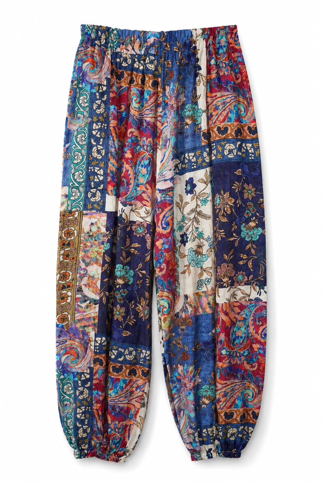 A pair of loose, patchwork-print harem pants featuring a vibrant mix of paisley, floral, and geometric patterns in blue, red, orange, and beige, displayed against a plain white background.