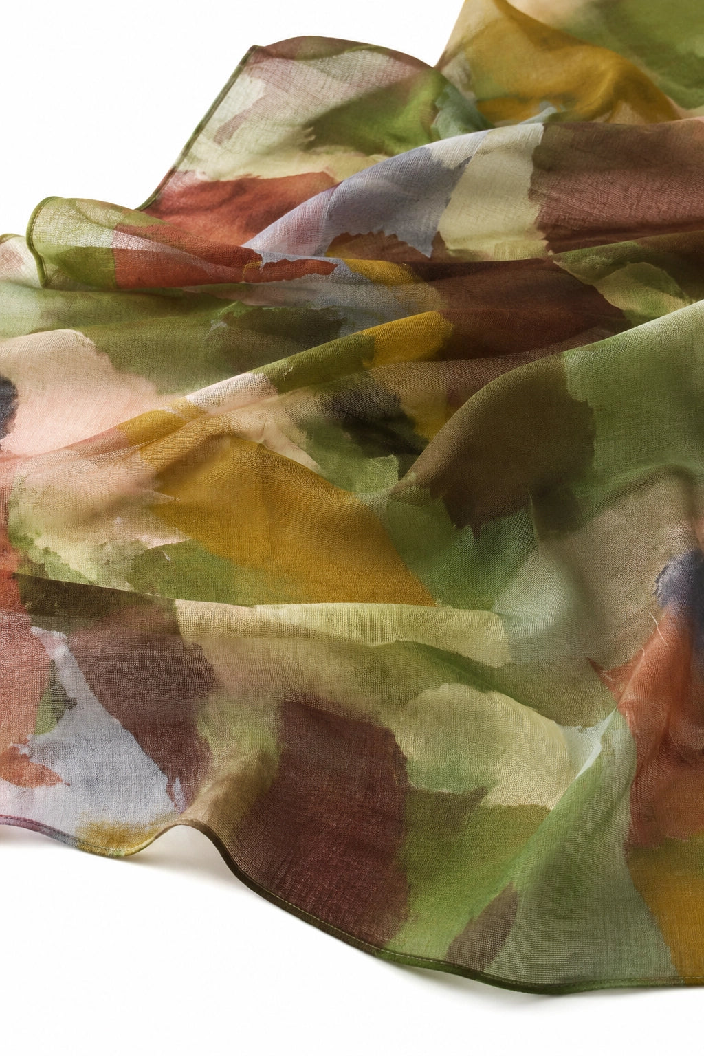 A lightweight sheer scarf with an abstract watercolor pattern in muted shades of olive green, mustard yellow, terracotta, and beige, draped against a white background.