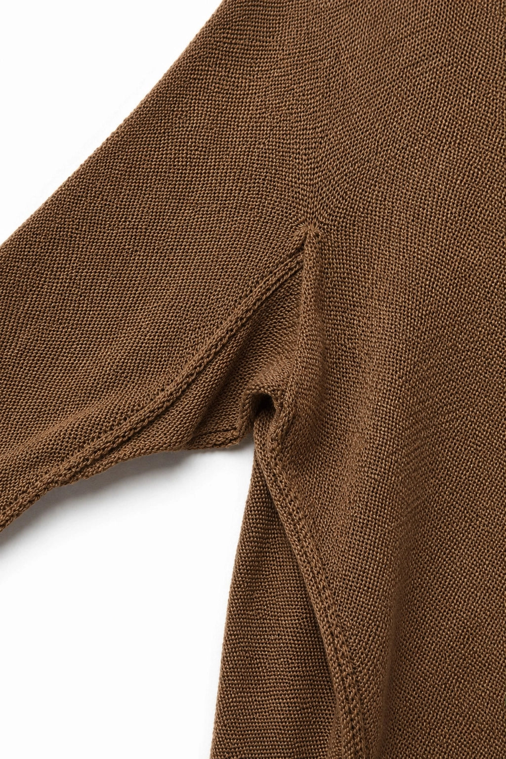 Close-up of a brown knit garment showing the sleeve seam and textured fabric against a white background.