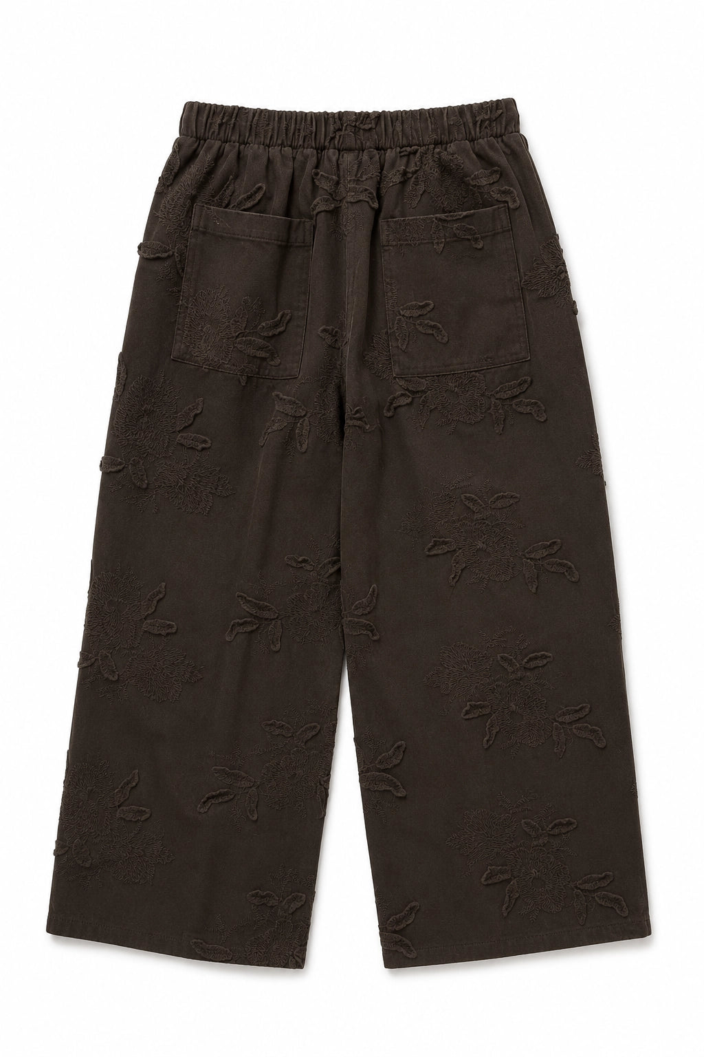 Dark brown cropped pants with an all-over tonal floral jacquard pattern, featuring an elastic waistband and side pockets, shown flat on a white background.