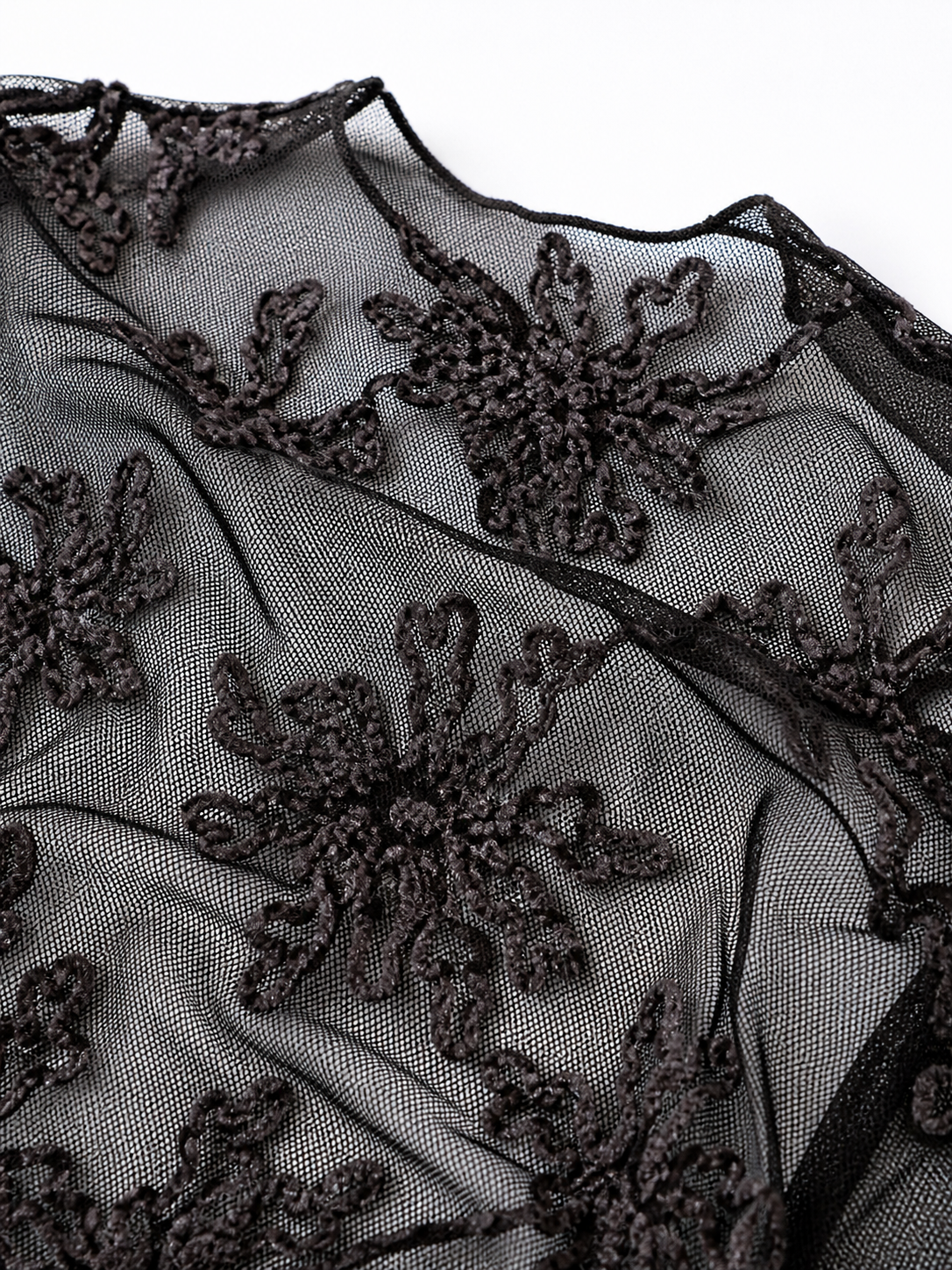 Black lace fabric with floral patterns on a white background