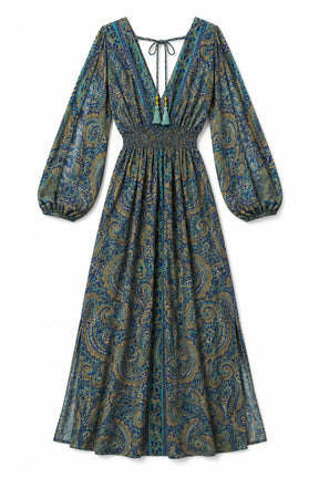 A long-sleeve midi dress with a deep V-neckline, tie-front detail, and a gathered waist, featuring an all-over paisley pattern in teal, blue, and gold tones, shown against a plain white background.