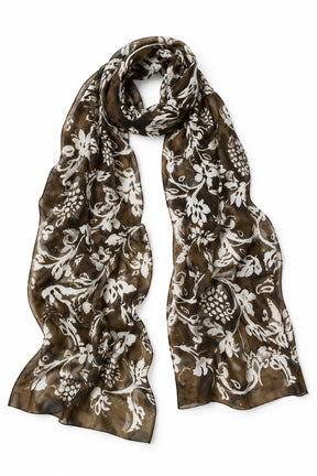 A lightweight scarf with an intricate white floral and vine pattern over a brown base, arranged in a draped loop on a clean white background.