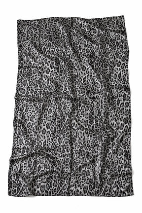 A rectangular textile item, likely a towel or blanket, featuring a black and white leopard print pattern, laid flat against a white background.
