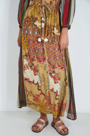 Person wearing a colorful patterned dress with a plain background
