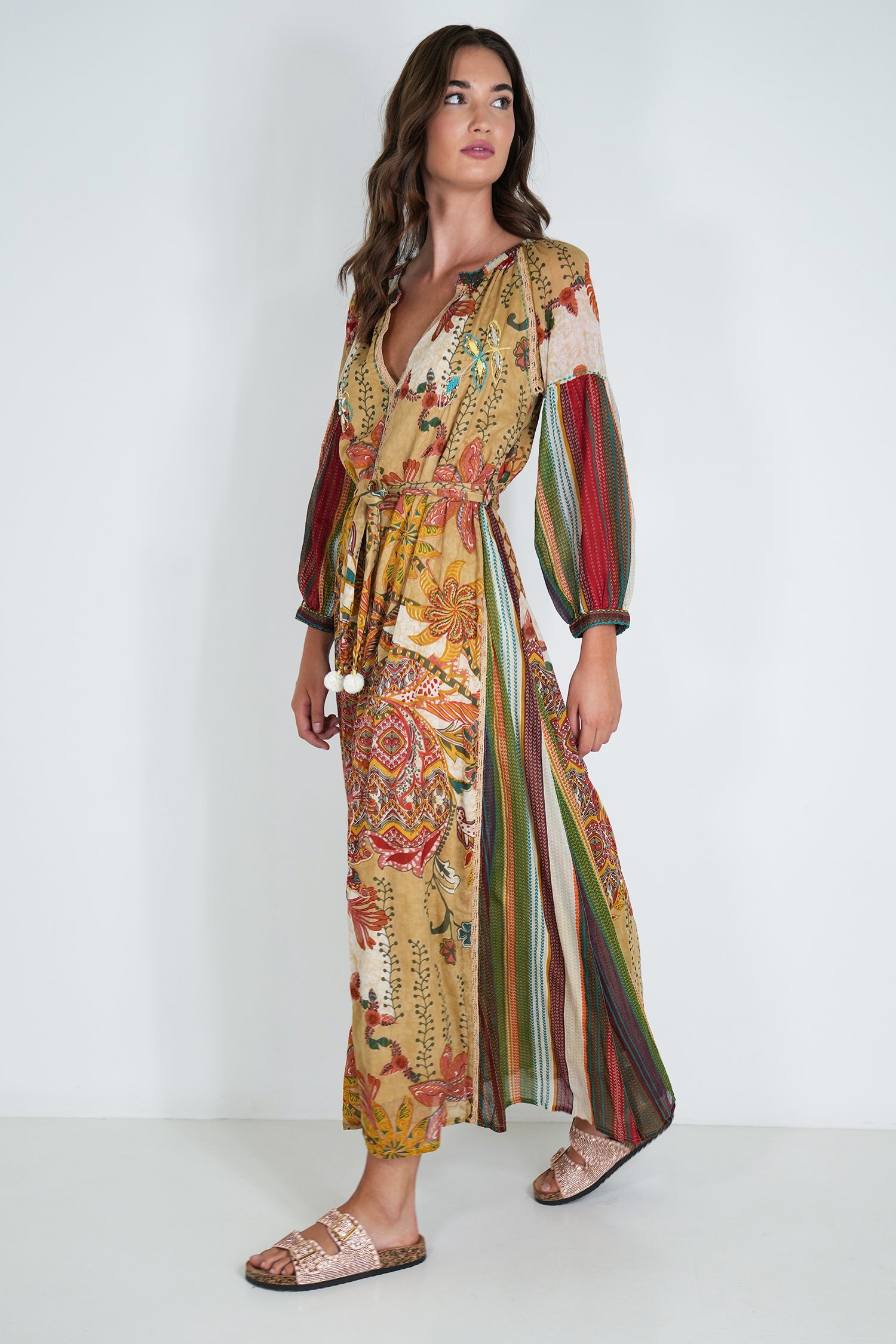 Woman wearing a colorful patterned dress on a white background