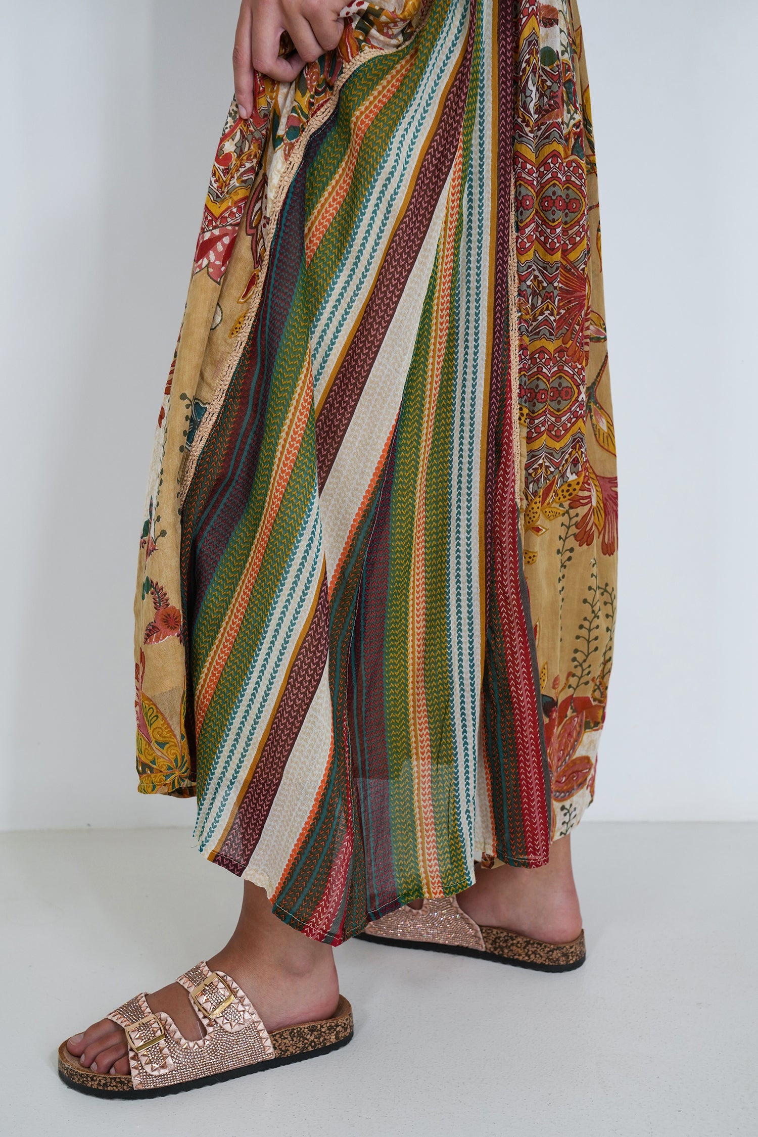 Colorful striped pants with patterned design worn by a person on a white background