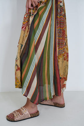 Colorful striped pants with patterned design worn by a person on a white background