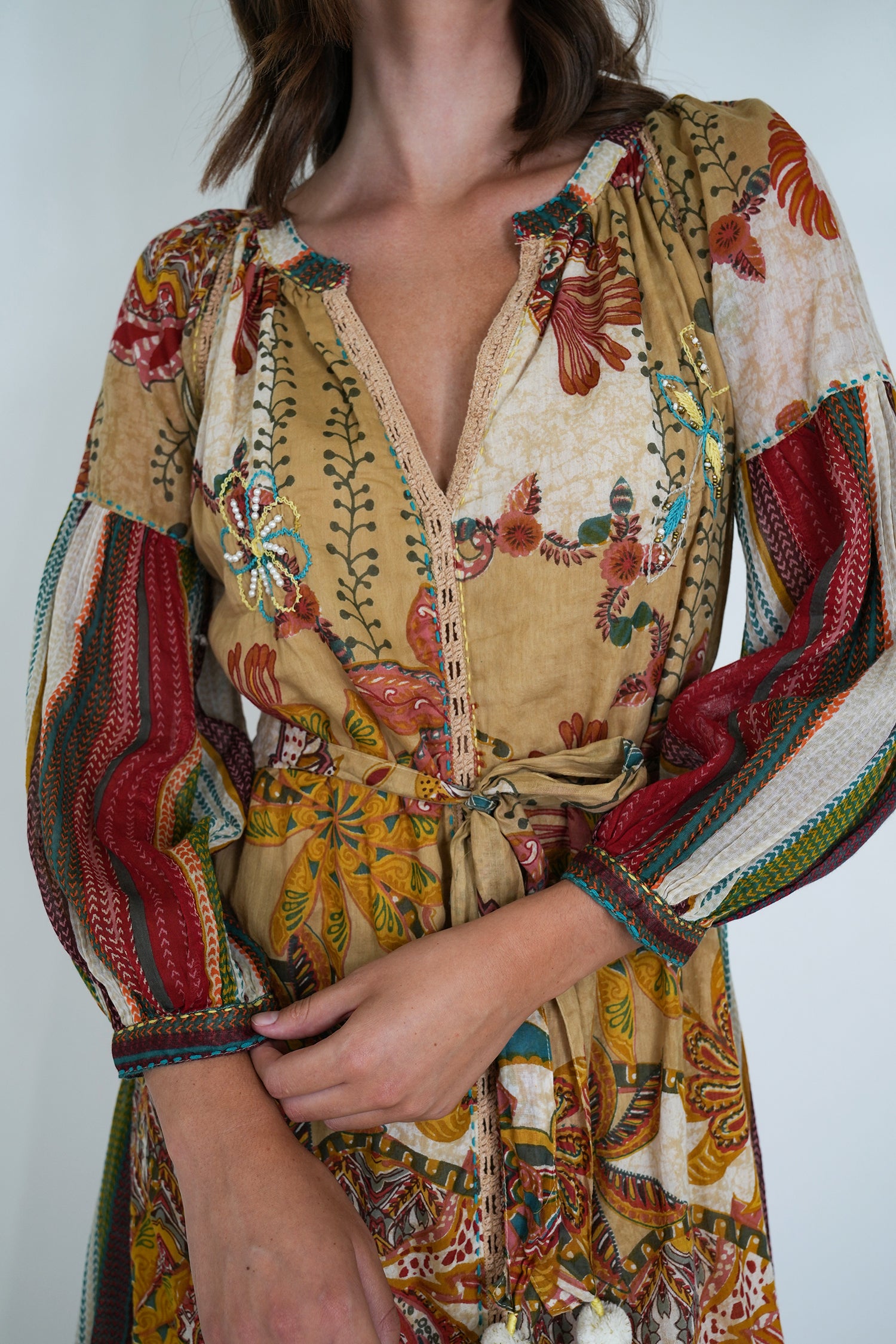 Colorful patterned dress with long sleeves on a plain background