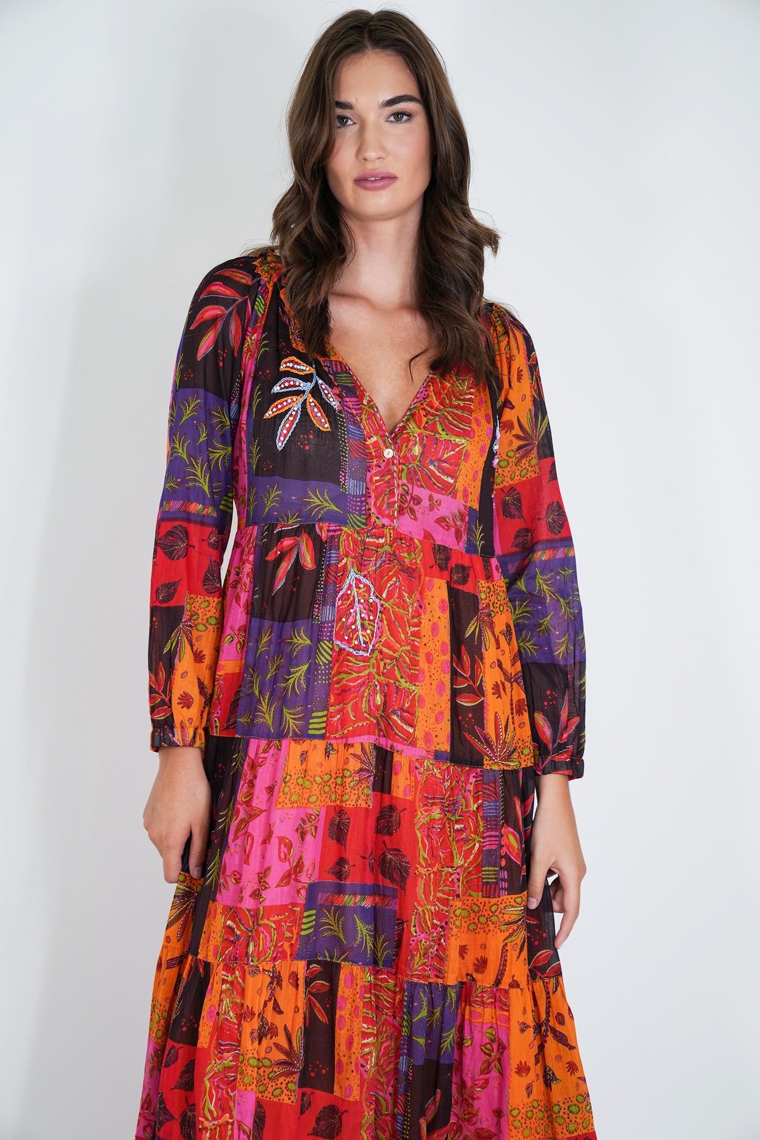 Woman wearing a colorful patterned dress on a white background