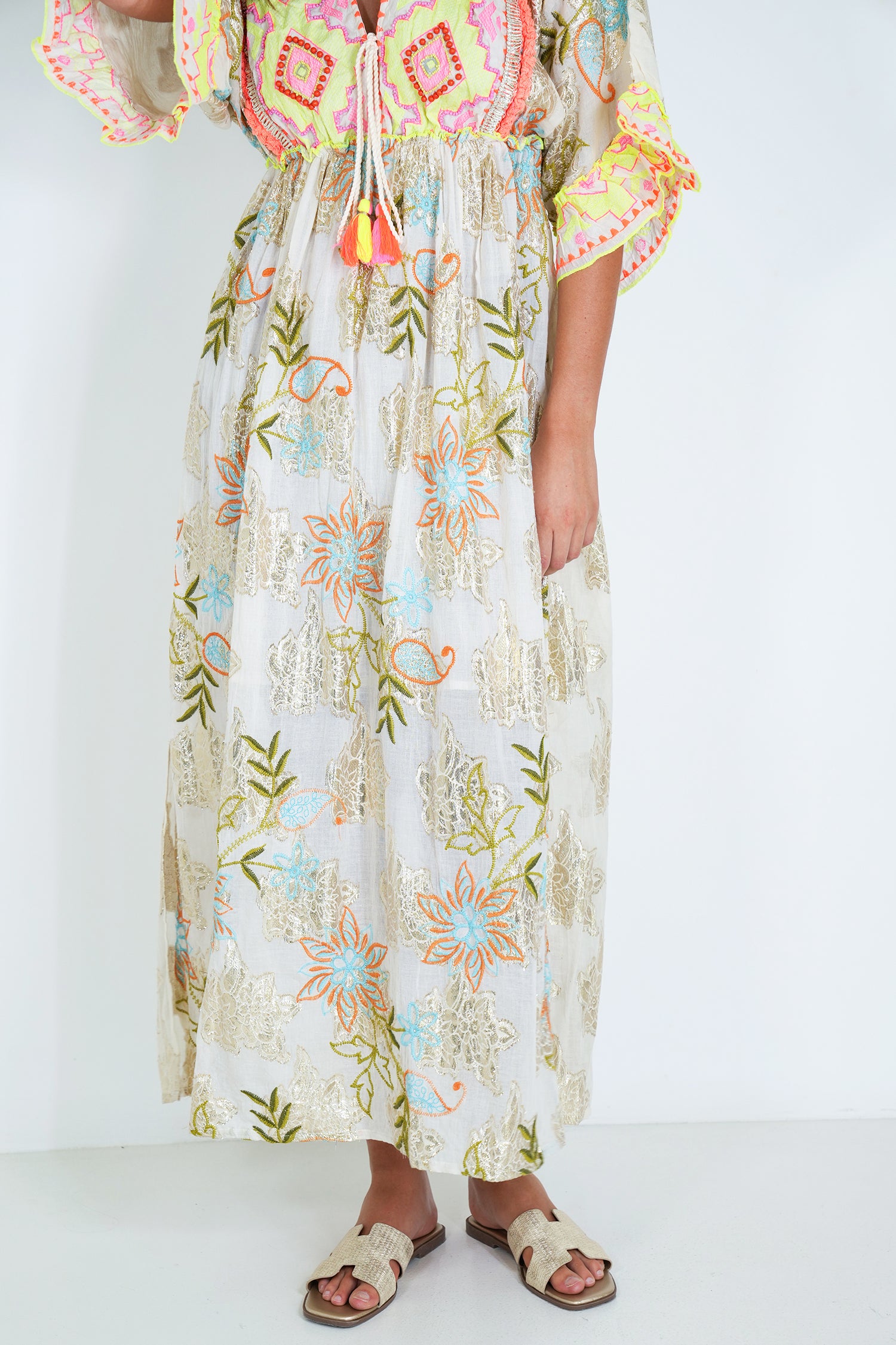 Person wearing a floral dress with colorful patterns on a white background
