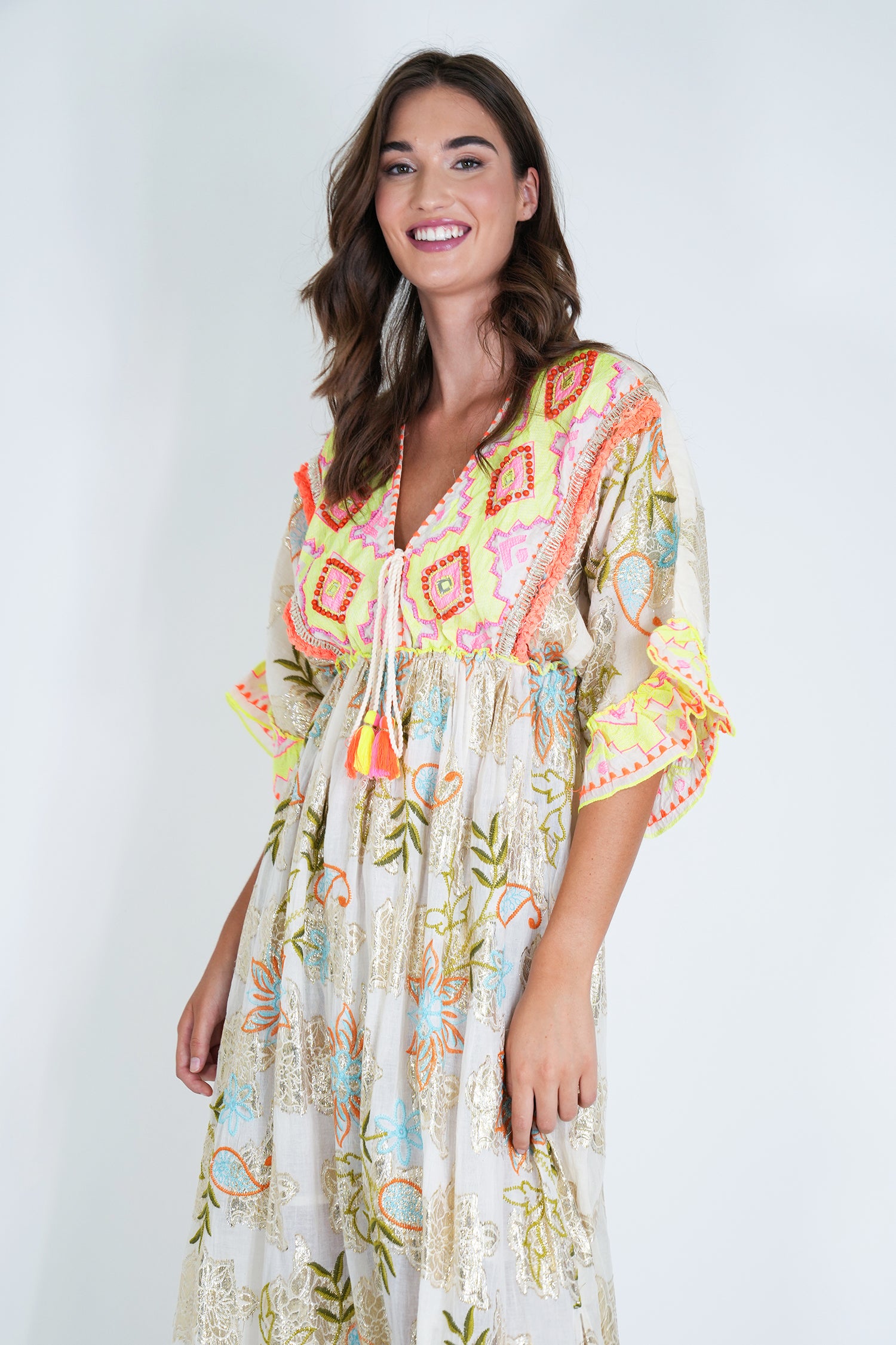 Woman wearing a colorful patterned dress on a white background