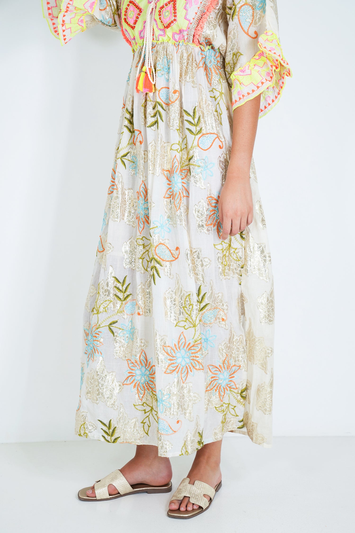 Person wearing a colorful floral dress on a white background