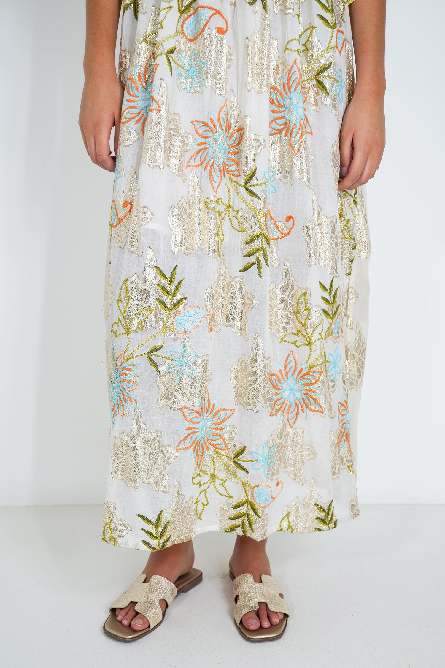 Person wearing a long floral dress on a white background
