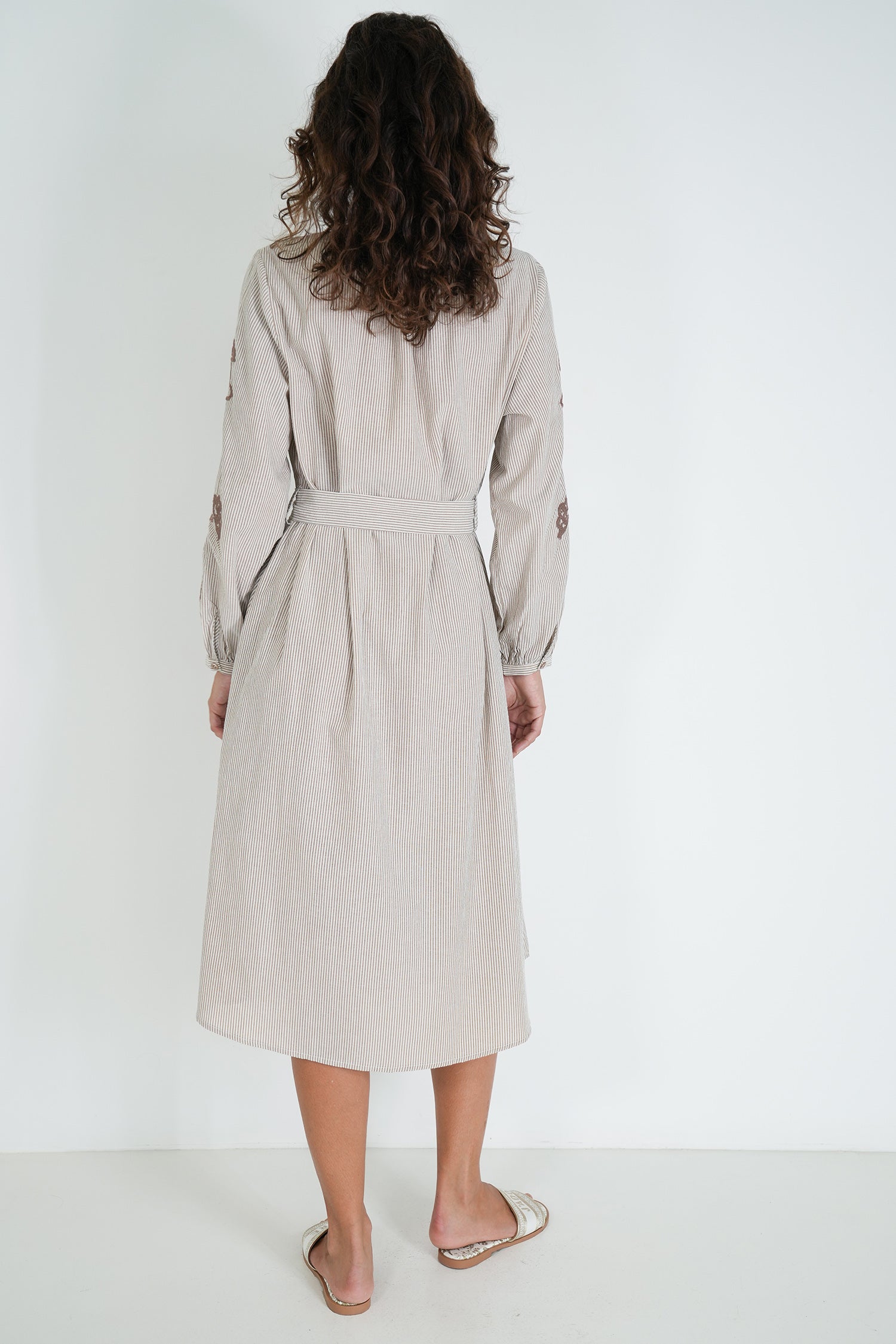 Woman wearing a beige trench coat on a white background