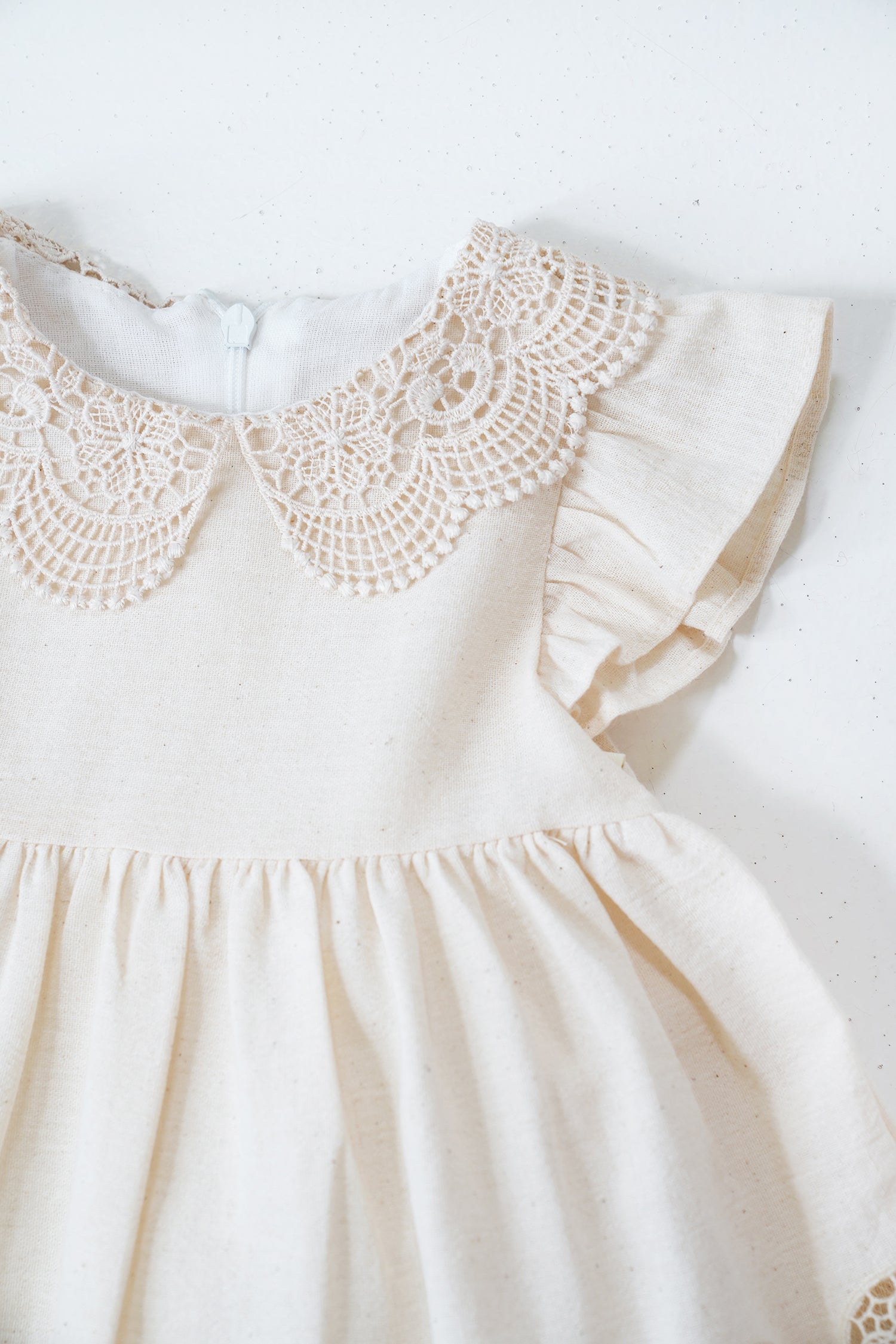 White dress with lace collar on a white background
