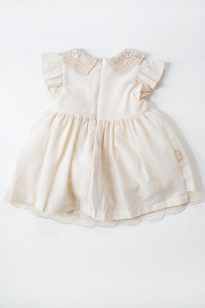 Cream-colored baby dress with lace details on a white background