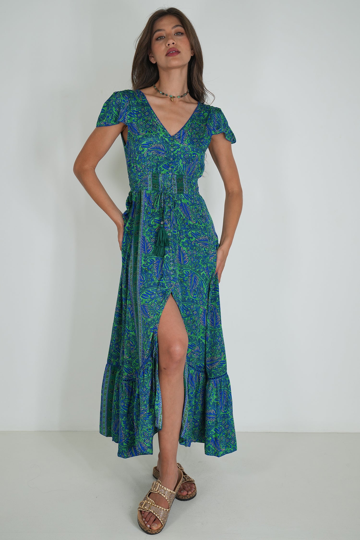 Woman wearing a green and blue patterned dress on a white background