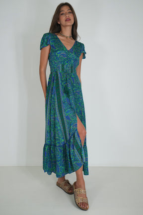Woman wearing a green and blue patterned dress on a white background