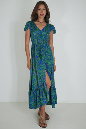 Woman wearing a green and blue patterned dress on a white background