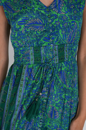 Green and blue patterned dress on a plain background