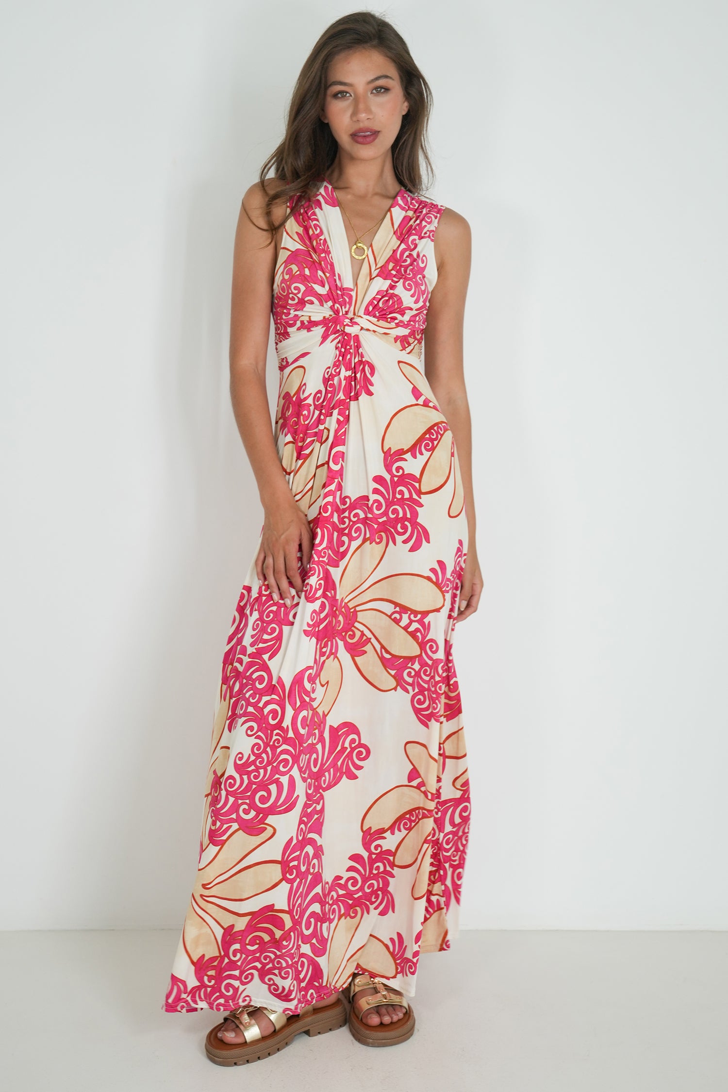Woman wearing a floral dress with pink and beige patterns on a white background