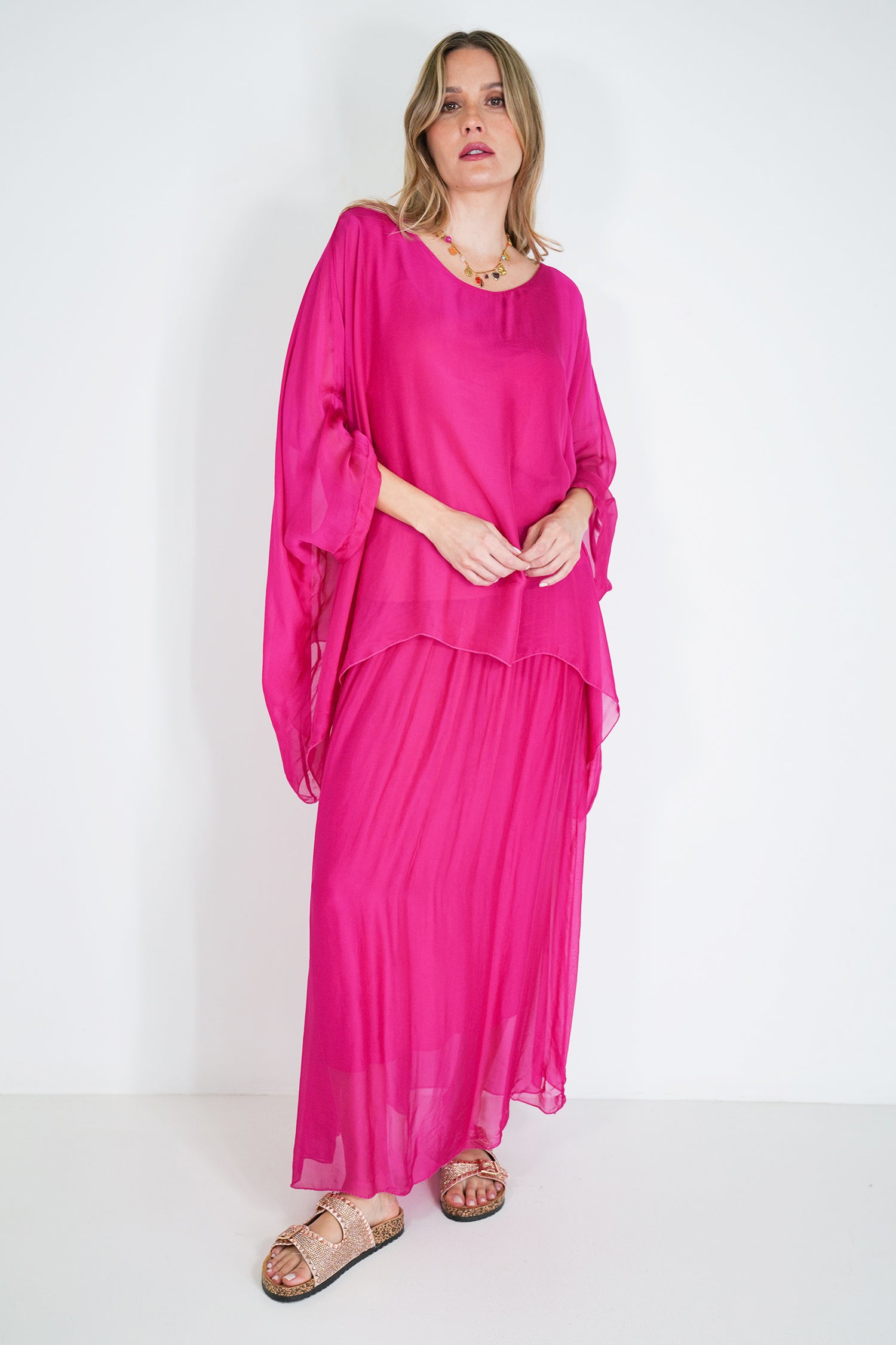Woman wearing a bright pink dress against a white background