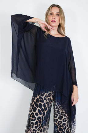 Woman wearing a black top and leopard print pants on a white background