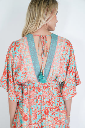 Woman wearing a colorful floral dress with a plain background