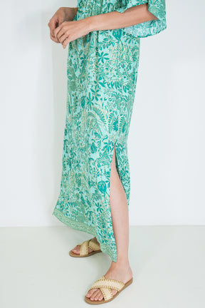 Green floral dress with a slit on a white background