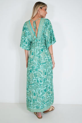 Woman wearing a green floral dress against a white background