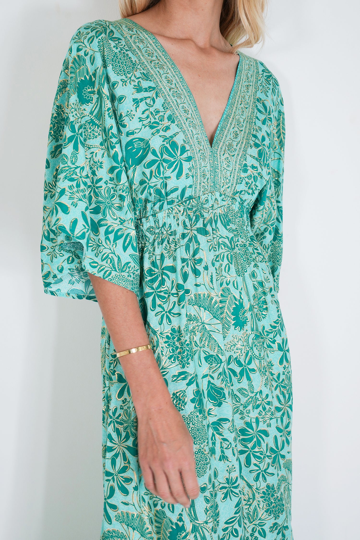 Green floral dress worn by a person on a white background