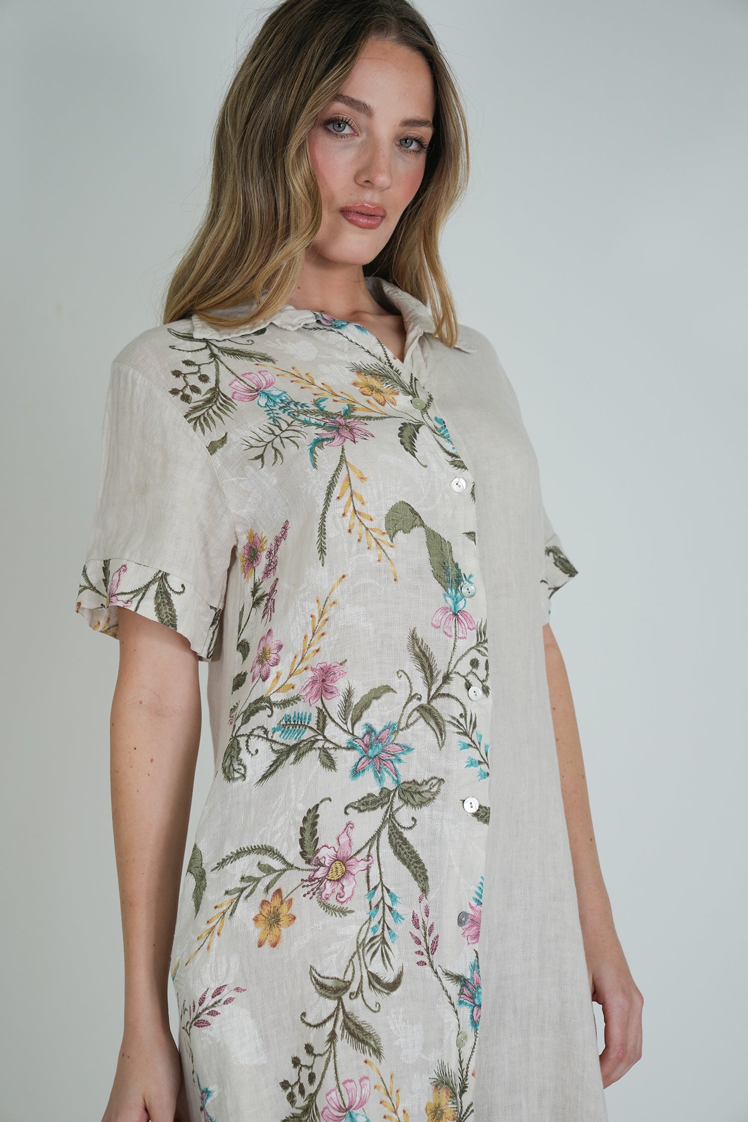 Woman wearing a floral dress against a plain background