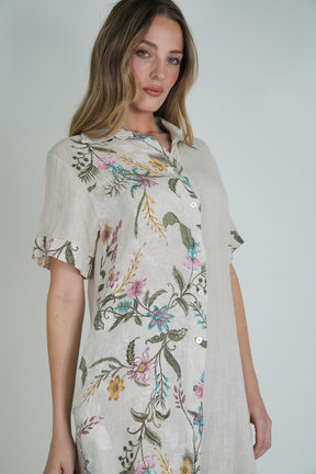 Woman wearing a floral dress against a plain background
