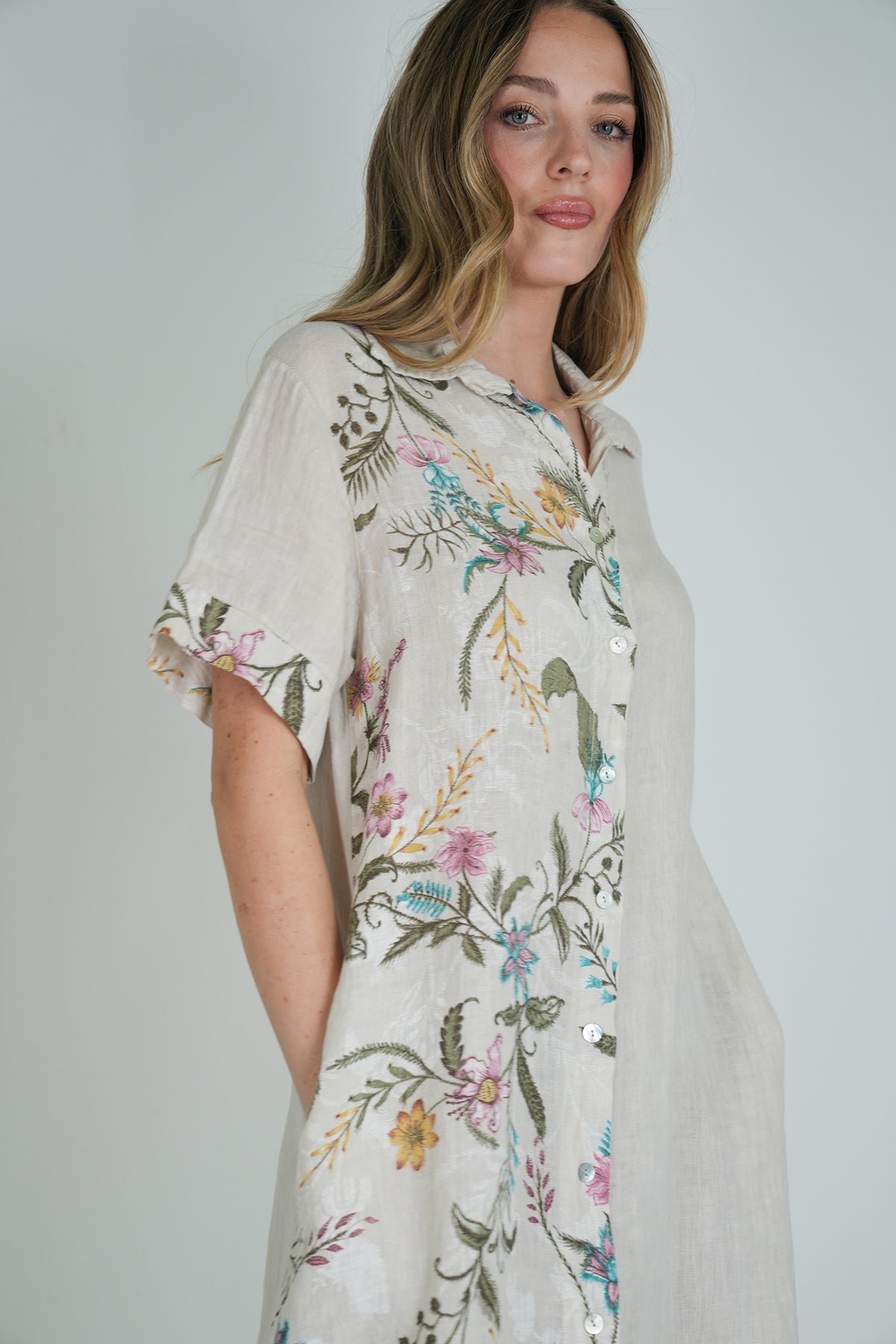Woman wearing a floral dress against a plain background