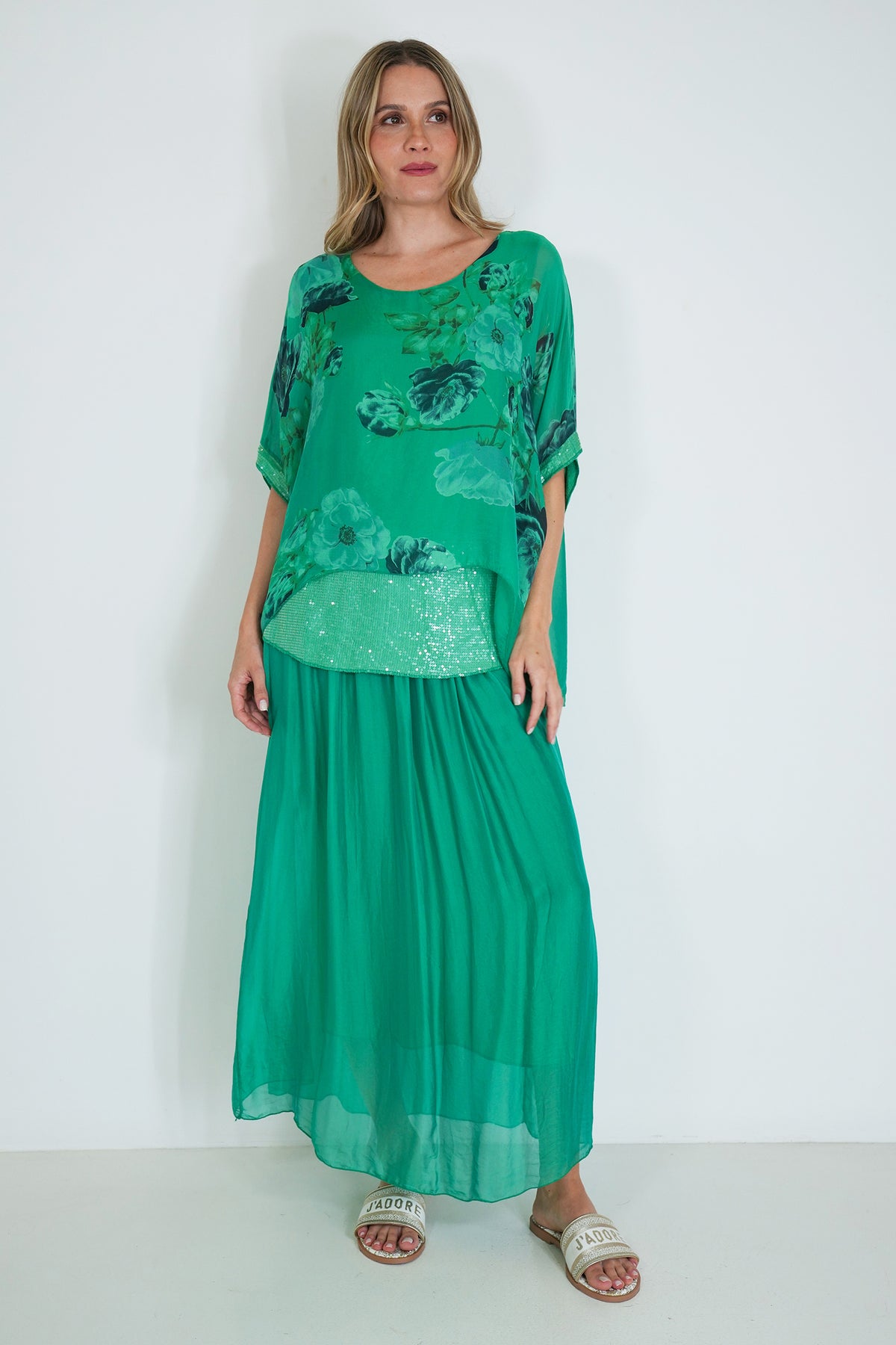 Woman wearing a green floral dress against a white background