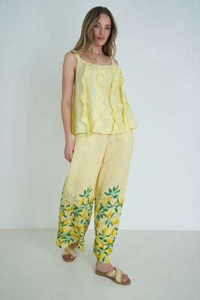 Woman wearing a yellow outfit with floral patterns on a white background