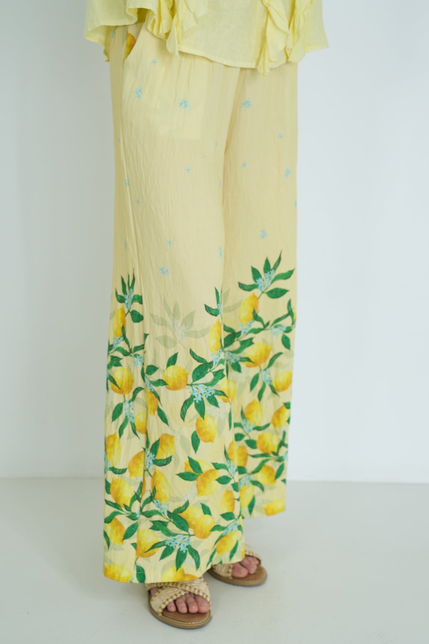 Yellow outfit with lemon pattern on a plain background