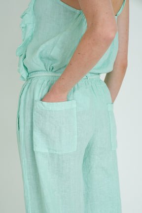 Mint green jumpsuit worn by a person on a plain background
