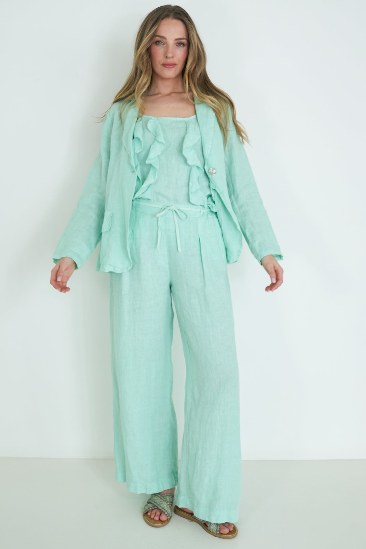 Woman wearing a mint green outfit against a white background
