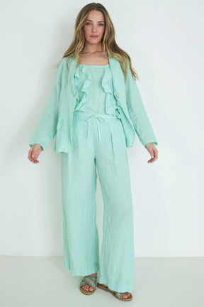 Woman wearing a mint green outfit against a white background