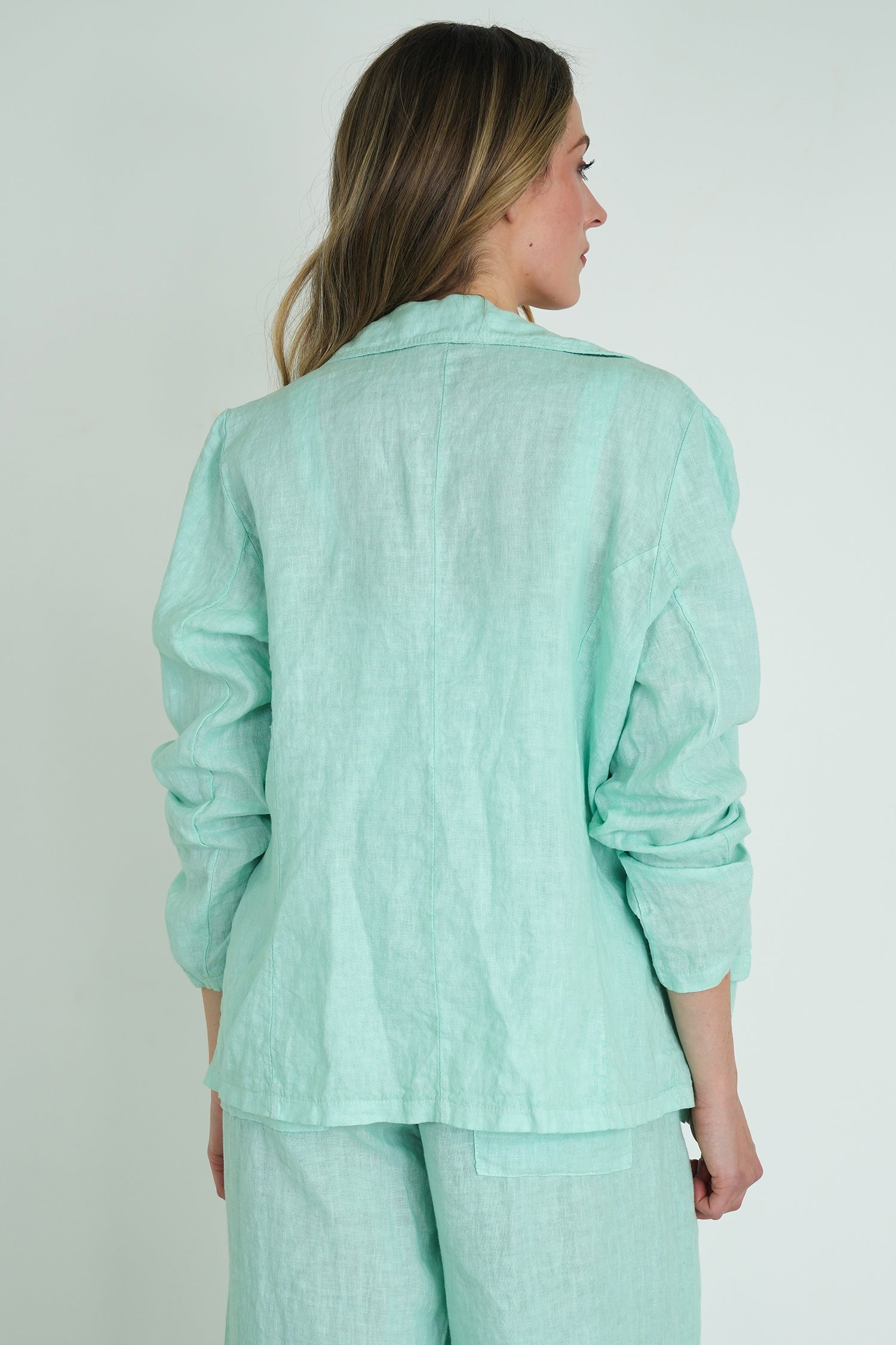 Woman wearing a light green outfit against a plain background