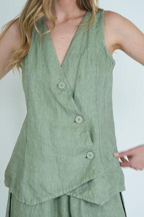 Green sleeveless top worn by a person on a white background