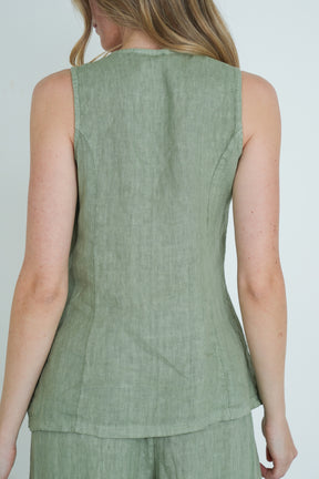 Green sleeveless top worn by a person on a plain background