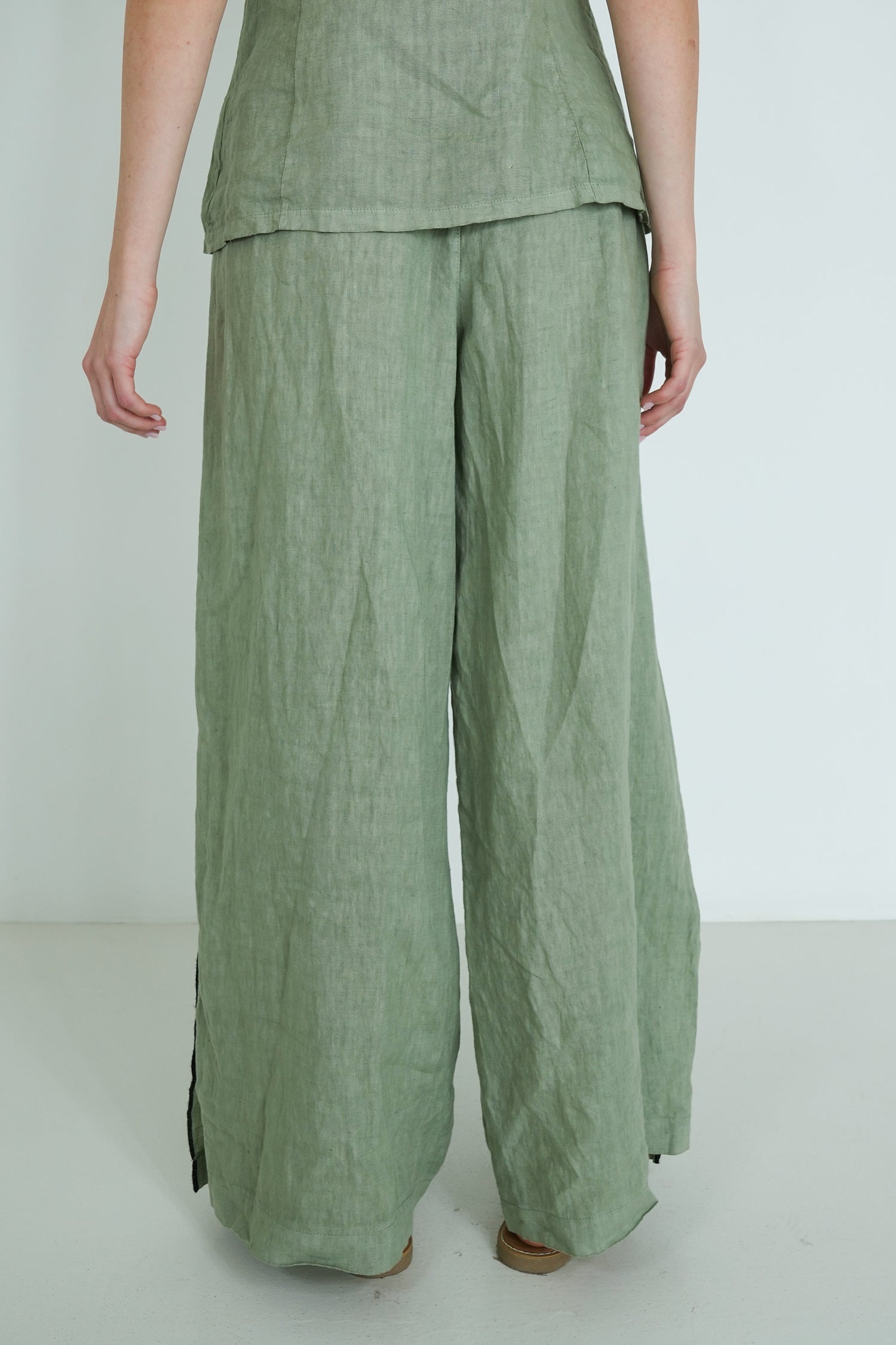 Green pants worn by a person on a white background