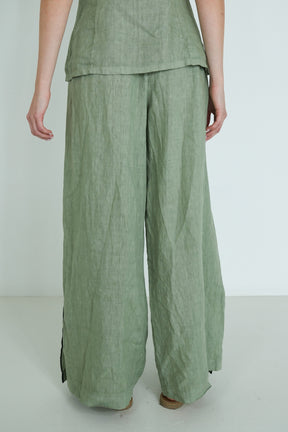 Green pants worn by a person on a white background