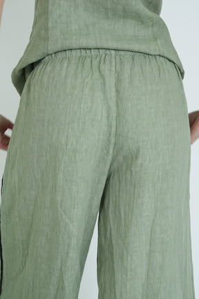 Green pants worn by a person on a white background